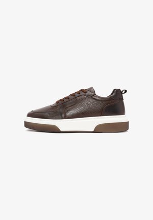 Sneaker en cuir brun avec une finition texturée, à bout rond, lacets bruns, une semelle intermédiaire blanche et une semelle extérieure en caoutchouc brun. Avec un tirant.
