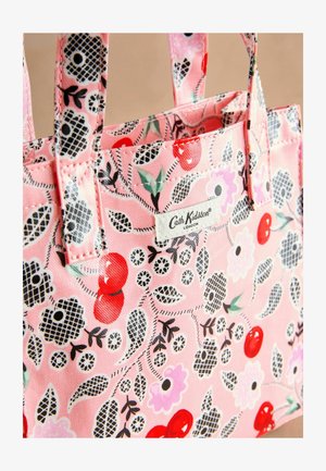 Rosa Stofftragetasche mit Blumen- und Kirschmuster. Verfügt über ein Logoschild und stabile Griffe. Strukturierten Oberfläche mit kontrastierenden Akzenten.