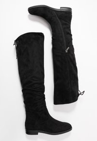 Stivali over-the-knee in suede nero con design a sbuffo, zip laterale e cordoncino regolabile. Suola piatta e texture liscia.