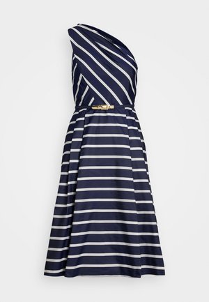 Abito navy con strisce bianche, design asimmetrico a spalla unica, corpetto aderente, gonna plissettata e una fibbia dorata in vita.