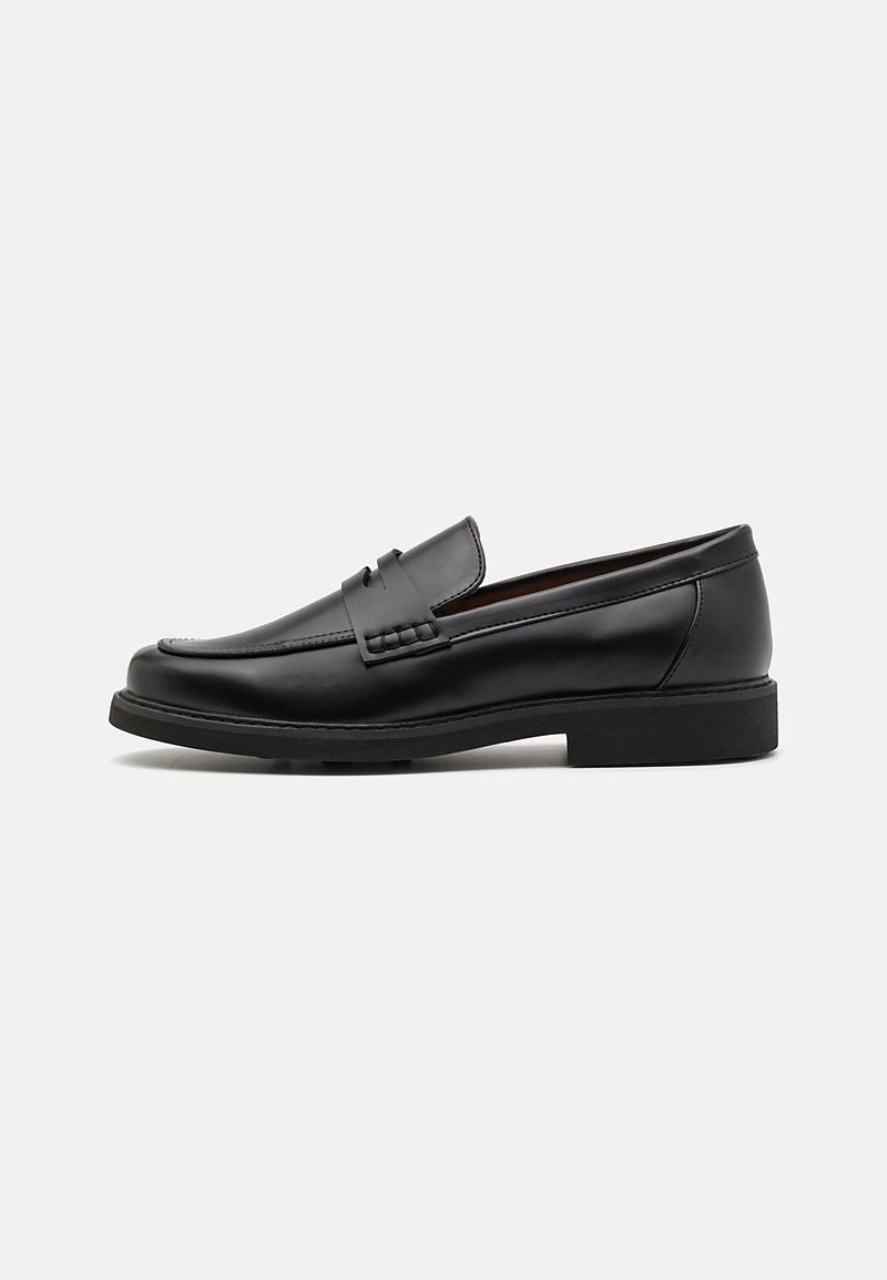 Schwarze synthetische Slipper mit einer markanten gesteppten Vorderseite, gepolstertem Fußbett und flacher Gummisohle; schlankes Design mit minimaler Detailverarbeitung.