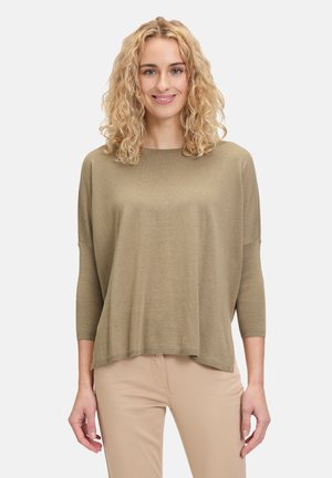 Maglione oversize verde oliva con scollo ampio e maniche a tre quarti, realizzato in un tessuto morbido e texture. La linea dell'orlo è leggermente curvata.