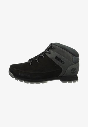 Scarpe da trekking nere con accenti grigi in materiale sintetico, colletto imbottito e design con lacci. Parte superiore testurizzata con dettaglio del logo sul lato.