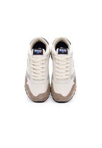 Zapatillas beige y grises con diseño de cordones, material de malla y ante, mediasuela acolchada, con suela negra y lengüeta de marca.
