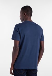 T-shirt in cotone blu navy con maniche corte, collo rotondo e una texture liscia. Vista posteriore che mostra un design semplice e senza decorazioni.
