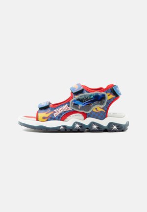 Children’s sandal with blue and red flame design, adjustable straps, a car graphic on the side, and light-up soles.