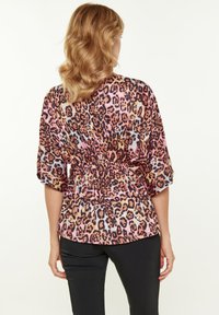 Leopardprint bluse i pink, orange og sort; blødt stof; indsnævret talje; brede ærmer; bagudskuende med afrundet kant og gathered design.