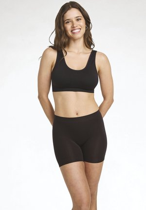 Black sports bra with wide straps and a scoop neckline paired with matching mid-thigh shorts. Smooth texture, stretchy material.