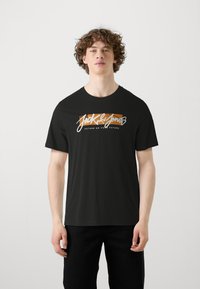 T-shirt in cotone nero con stampa grafica bianca e arancione recante il testo "Jack & Jones" e "FUTURE OR YOUR FUTURE". Maniche corte.