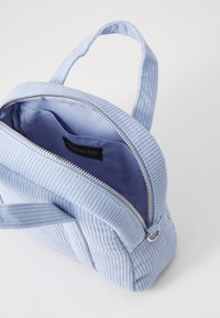 Sac à main en velours côtelé bleu avec fermeture éclair, doté d'une doublure intérieure bleue contrastante et d'une poignée supérieure pour le transport.