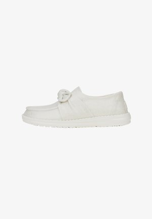 Scarpe slip-on bianche con un accentuato nodo sulla parte superiore, realizzate in tessuto testurizzato, dotate di una suola in gomma flessibile.