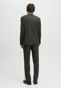 Dunkelgrüner maßgeschneiderter Anzug mit strukturiertem Blazer und geraden Hosen, gefertigt aus einem strukturierten Stoff und minimalistischem Design, von hinten betrachtet.