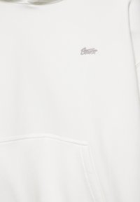Sweat à capuche blanc avec un petit logo gris brodé sur la poitrine et une poche kangourou à l'avant.