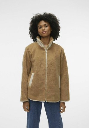 Veste en polaire marron avec un col haut, fermeture zippée et poches crème. Dotée d'une texture douce et d'une coupe décontractée.