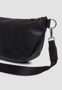 Zwarte leren tas met een geribbeld textuur, gebogen ontwerp, metalen hardware en een verstelbare nylon schouderband. Bevat een veilige sluiting en logo.