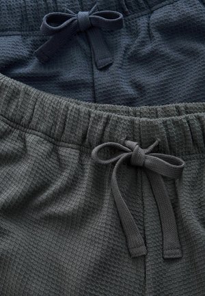 Zwei Paar strukturierte Shorts in Dunkelblau und Dunkelgrau, mit elastischen Taillengummis und passenden Stoffbindungen. Jede Shorts hat ein dezentes Waffelmuster.