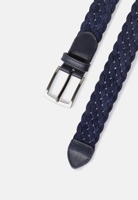 Cinturón trenzado azul marino de tela tejida con detalles de cuero, que cuenta con una hebilla rectangular de metal plateado y una punta de cuero suave.