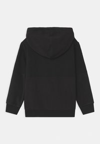 Felpa nera con cappuccio caratterizzata da una texture morbida, una vestibilità comoda e polsini a costine. Il design è minimalista con un attacco del cappuccio senza cuciture.