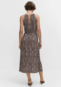 Robe sans manches à motifs bruns et crème avec un dos en trou de serrure et une silhouette fluide, atteignant le milieu du mollet, présentant une taille cintrée.