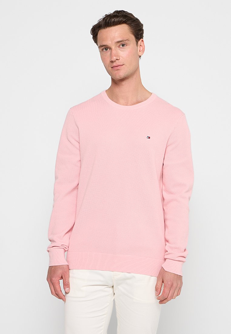 Hellrosa gestrickter Pullover mit Rundhalsausschnitt, langen Ärmeln und kleinem Logo auf der Brust. Verfügt über strukturierte Stoffqualität und gerippte Bündchen.