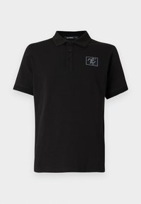 Černé polo tričko vyrobené z bavlny, s dvouknoflíkovou légou, krátkými rukávy a malou kontrastní nášivkou loga na hrudi.