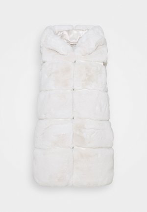 Manteau sans manches en fausse fourrure blanche avec grands panneaux matelassés et large col, posé à plat sur un fond blanc.