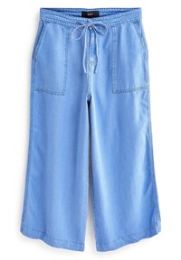 Hellblaue weit geschnittene Jeanshosen mit elastischem Bund und Kordelzug sowie zwei aufgesetzten Taschen auf der Vorderseite.