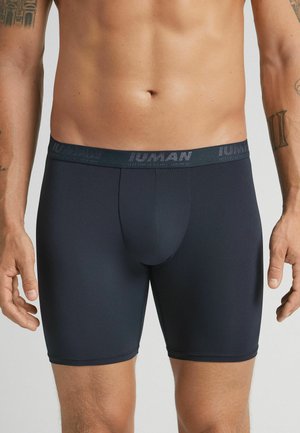 Mørkeblå herre boxershorts lavet af glat, strækbart stof. Har en mærket elastisk talje og en tætsiddende pasform.