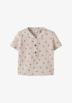 Chemisette beige pour tout-petit à manches courtes, motif quadrillé marron, petits ancres marines bleu marine, trois boutons en bois sur la patte de boutonnage avant, col rond.