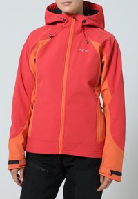 Veste softshell rouge et orange avec capuche, dotée de poches zippées et de poignets ajustables. Le design comprend des panneaux de couleur contrastante.
