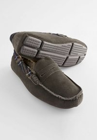 Grijze suède moccasin-slippers met een geblokte stofvoering en een rubberen zool met textuurlijke grippatronen. Instapstijl met gestikte details.