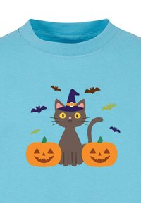 Blå bomulds t-shirt med en grå kat iført en lilla heksehue, flankeret af to orange græskar med smilende ansigtstræk, og flyvende flagermus.