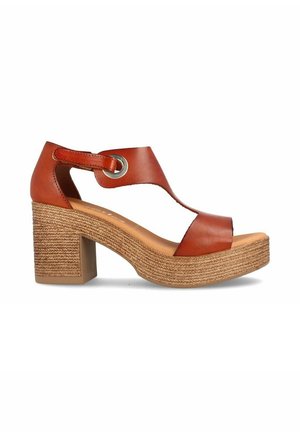 Sandalias de tacón de cuero marrón con plataforma de yute trenzado, diseño de punta abierta, un acento metálico circular y correa ajustable en el tobillo.