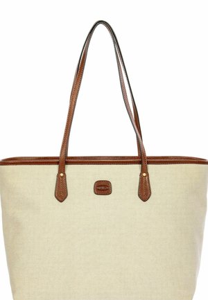 Bolsa tote de lona beige con ribete y asas de cuero marrón, con un pequeño parche de logo de cuero centrado debajo de las asas.