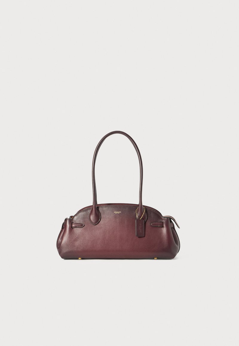 Borsa a mano in pelle borgogna con forma arrotondata, manici doppi, tasche laterali e hardware dorato. Presenta un'etichetta pendente con il logo del marchio.
