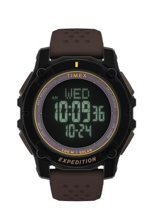 Digitální hodinky Timex Expedition s černým kulatým ciferníkem, hnědým páskem, zobrazující čas, datum, den a označení solární voděodolnosti 100 m.