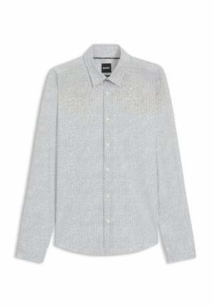 Camicia bianca a maniche lunghe con un fine motivo a pois neri, colletto con bottoni e patta con bottoni abbinati. Tessuto morbido.