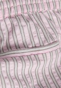 Ροζ ύφασμα με κάθετες άσπρες και καφέ ρίγες, με ζωνάκι που συγκεντρώνεται και ραμμένη τσέπη.