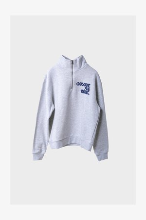 Lys grå genser med halv glidelås og marineblå tekst "COLOURFUL REBEL" på venstre bryst, lange ermer og ribbestrikkede mansjetter og hem.