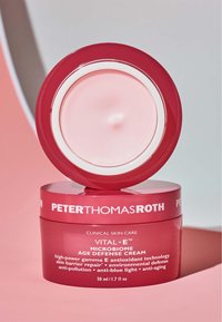 Rosa rund burk med Peter Thomas Roth Vital-E Microbiome Age Defense Cream med vita accenter. Krämen inuti har en jämn textur. 50 ml.
