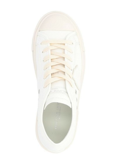 Sneaker bianco in pelle con punta arrotondata, lacci piatti, dettagli perforati e logo sul lato. Texture liscia e design minimal.