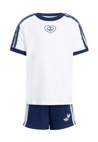 Biele tričko s krátkym rukávom a tmavomodrými akcentmi a srdcovým logom, doplnené tmavomodrými šortkami s bielymi bočnými pruhmi a detailom loga.