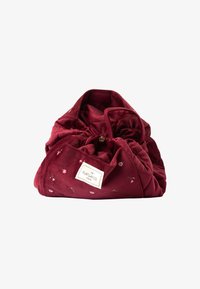 Bolsa de cordón burdeos hecha de tela suave, con bordado floral y una etiqueta con "The Flat Lay Co." en un parche bordado.