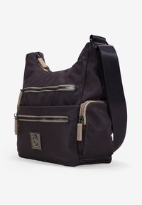 Bolso de hombro de nailon en púrpura oscuro con múltiples bolsillos con cremallera, acentos en beige y una correa tejida. Presenta una etiqueta de marca en la parte delantera.
