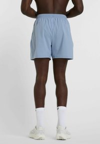 Light blue athletic shorts with an elastic waistband, smooth texture, above-the-knee cut, and two side pockets.