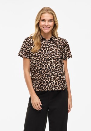 Īsām piedurknēm leopardu raksta blouse tan un melnā krāsā, ar pogām priekšpusē, ar oderi, gluda tekstūra, saskaitīta ar melnām biksēm.