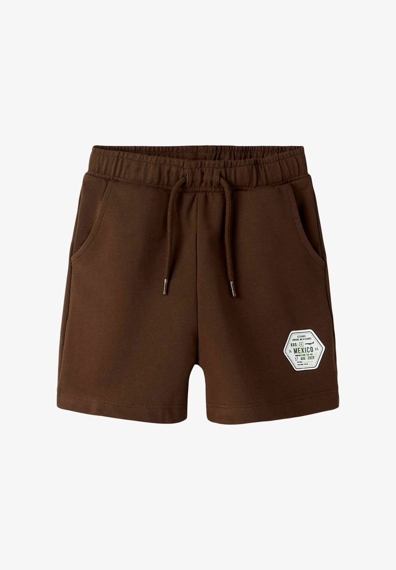 Short en coton marron avec taille élastique, cordon, deux poches avant et écusson hexagonal blanc sur la partie inférieure de la jambe droite.