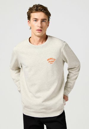 Ljusgrå sweatshirt med rund hals, långa ärmar och en texturerad yta. Har en orange "Wrangler Jeans 1947"-logotyp på bröstet.