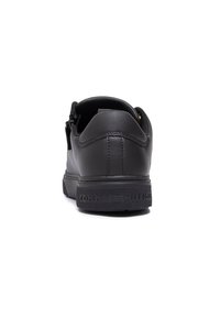 Sneaker nera in pelle con retro testurizzato, suola piatta e logo "TOMMY HILFIGER" in rilievo. Finitura liscia e design del tallone arrotondato.