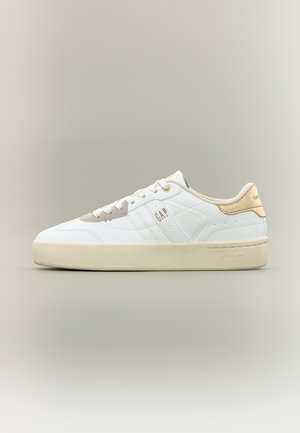 Scarpa da ginnastica bianca con tomaia bassa, inserto in camoscio beige sul tallone, suola color crema, lacci bianchi e logo "GAP" sul lato e sul tallone.